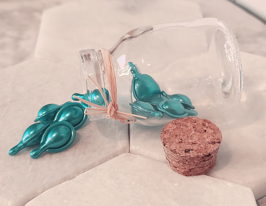 Small turquoise facial serum beads in a jar